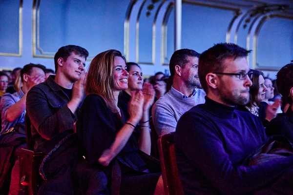 Public applaudissant lors d&rsquo;un &eacute;v&eacute;nement dans une salle &eacute;l&eacute;gante