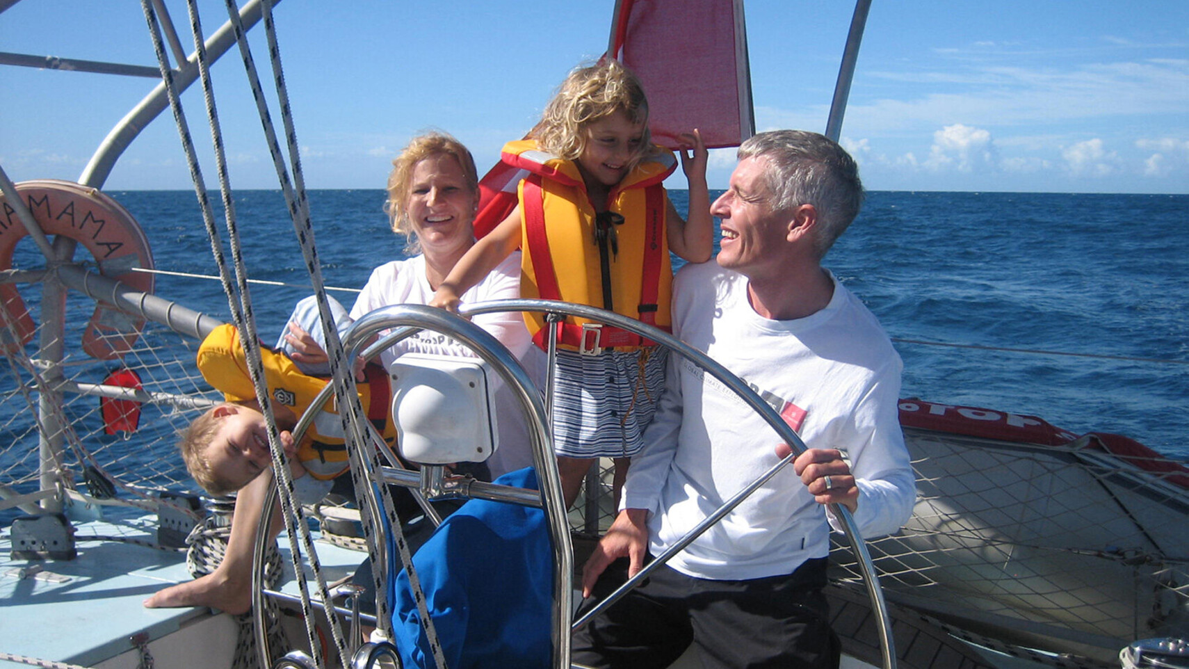 TOPtoTOP-expeditiefamilie Schw&ouml;rer aan het roer van hun zeilboot in tropisch water bij Bundaberg, Australi&euml; &ndash; kinderen met reddingsvesten, zonnige oceaanoversteek, 2009